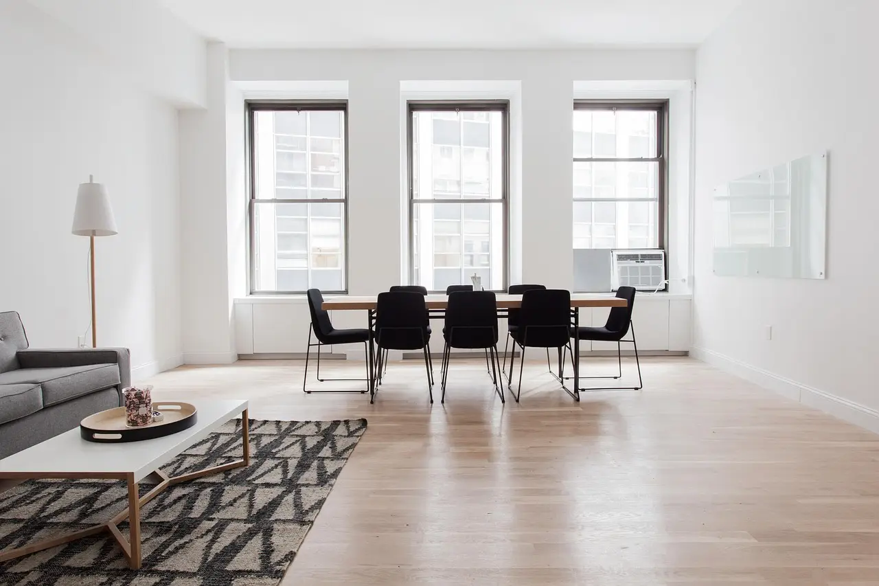Séjour d’appartement rénové, parquet clair et hautes fenêtres